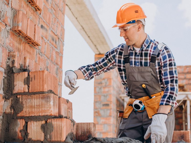 Young craftsman building a house